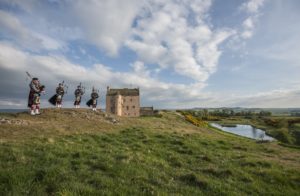Four pipers perform in front of historic backdrop of Fenton Tower